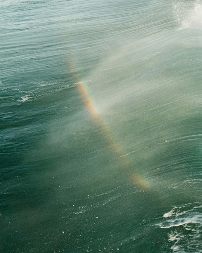 Rainbow appears on a breaking ocean wave
