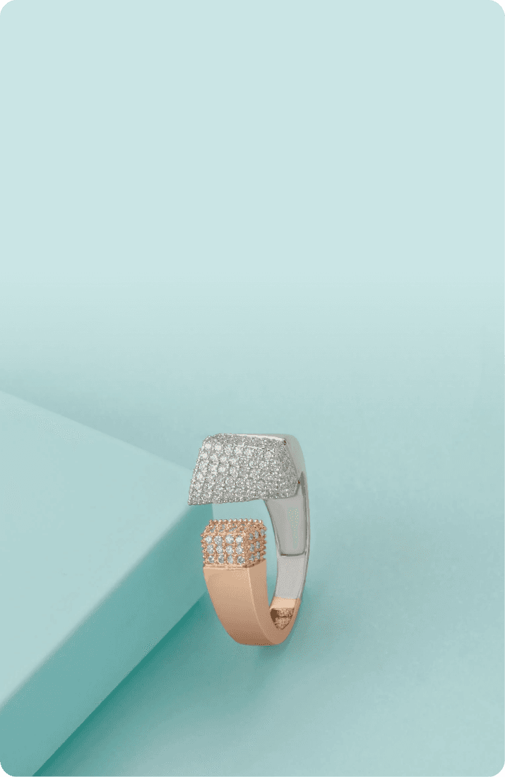 Rose gold and silver ring displayed on a light teal background.