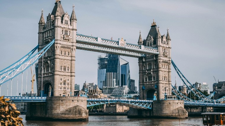 Tower Bridge in London spanning the River Thames with the city skyline in the background.