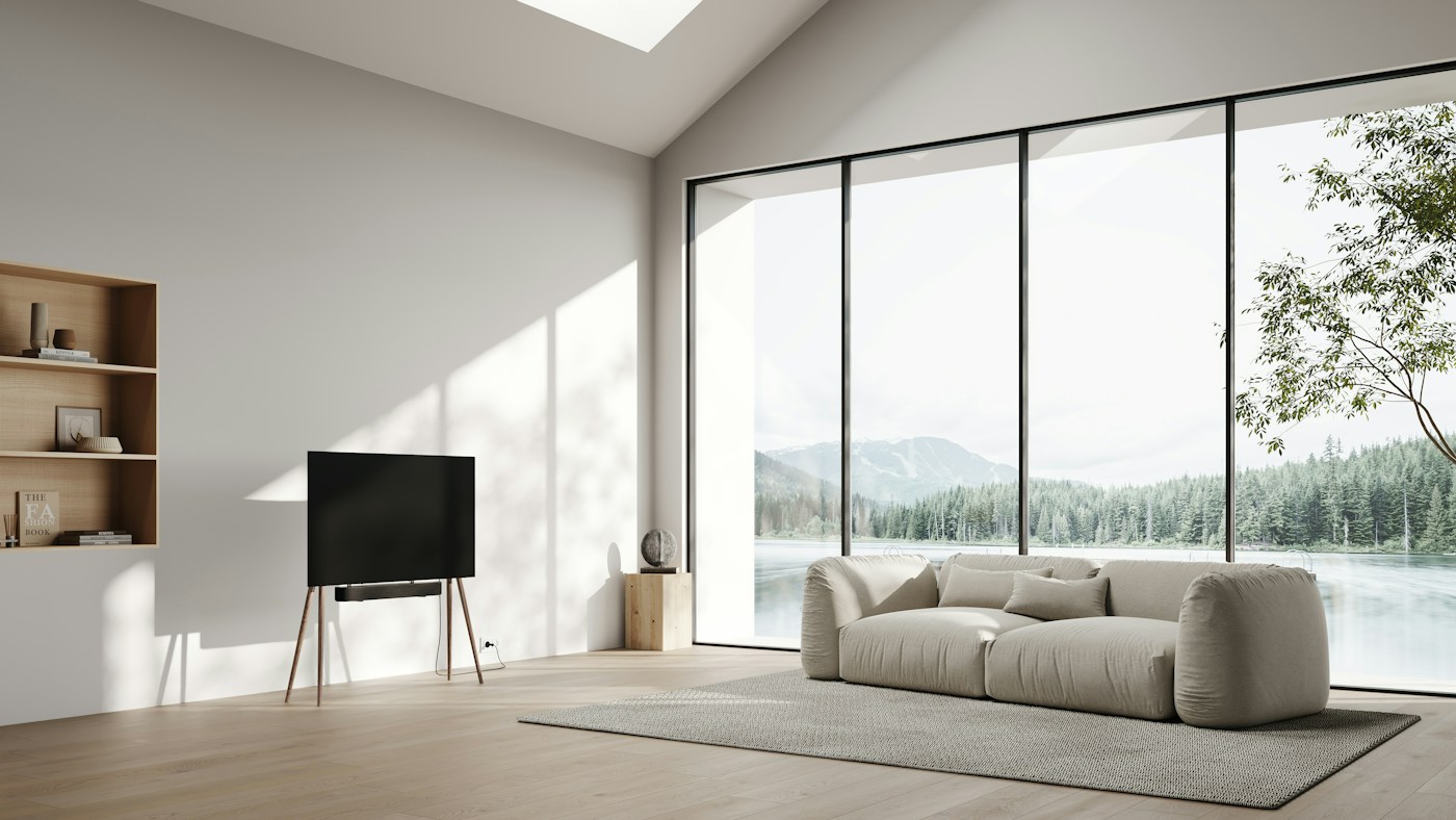 A white living room with a corner window looking out to trees