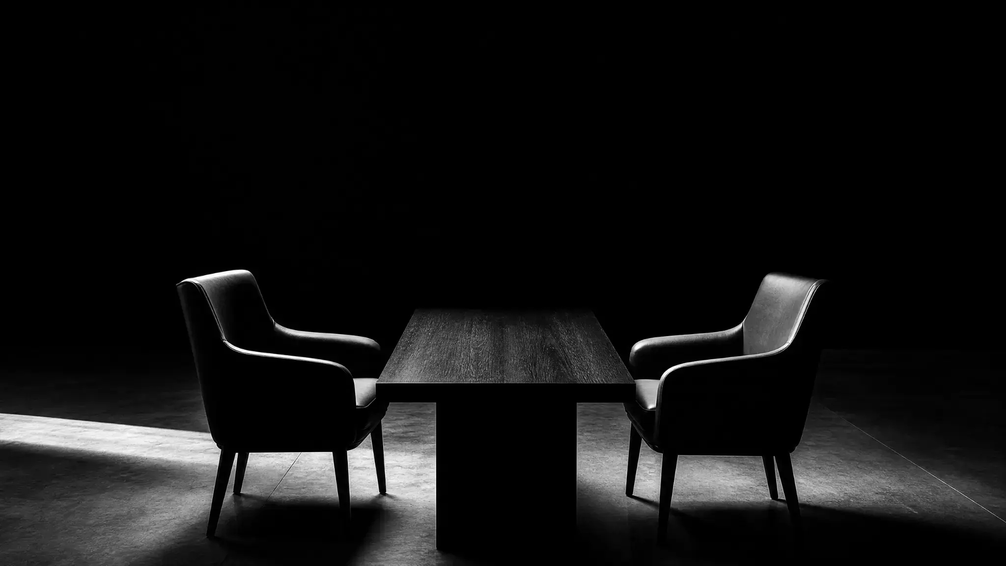 Photographie noir et blanc de deux fauteuils face à face, symbolisant l'accompagnement en droit du travail à Paris par STC Avocat.