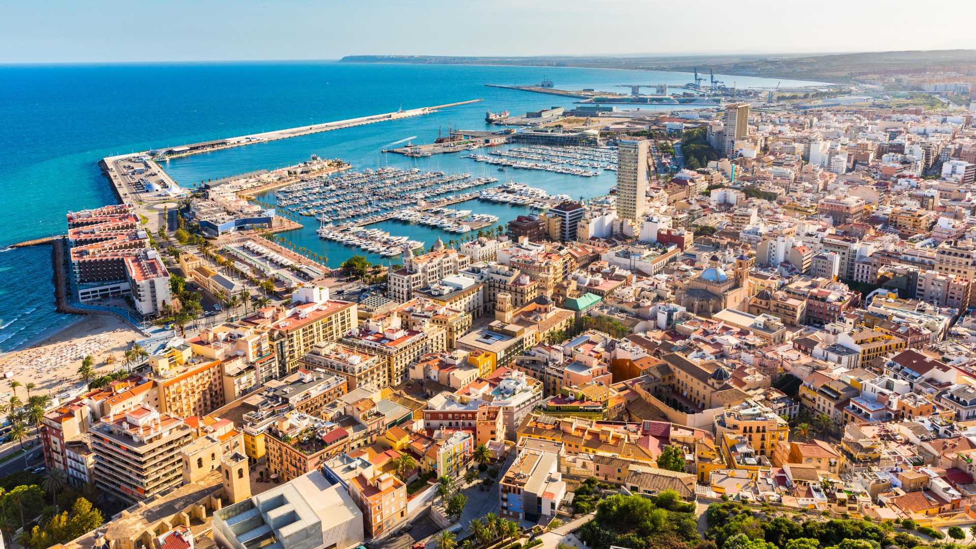 Vista aérea de Alicante con el puerto deportivo y la zona urbana iluminada por el sol