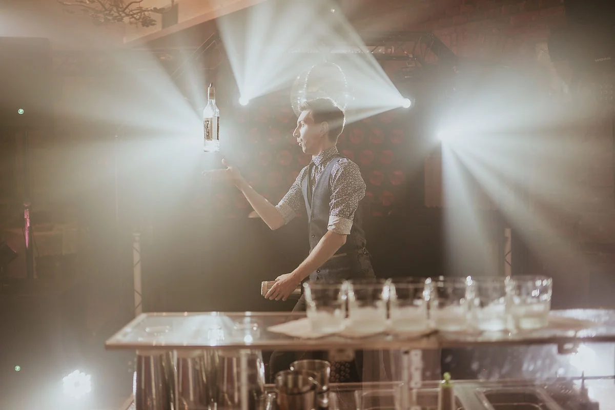 Atrakcje na event – barman prowadzi interaktywny pokaz barmański.