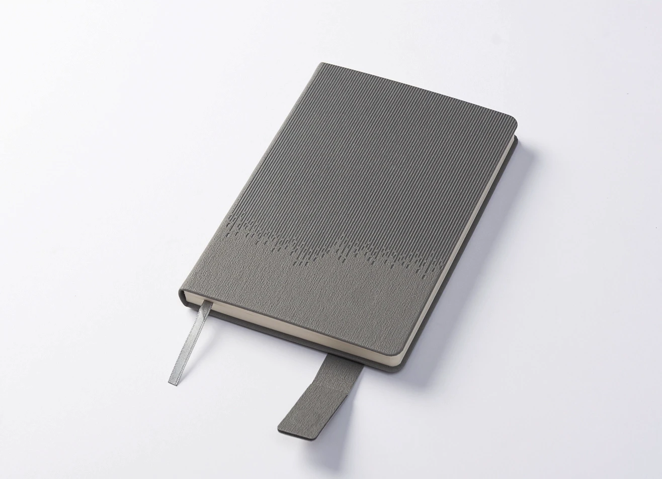 Closed grey journal showing vertical ribbed texture and strap closure