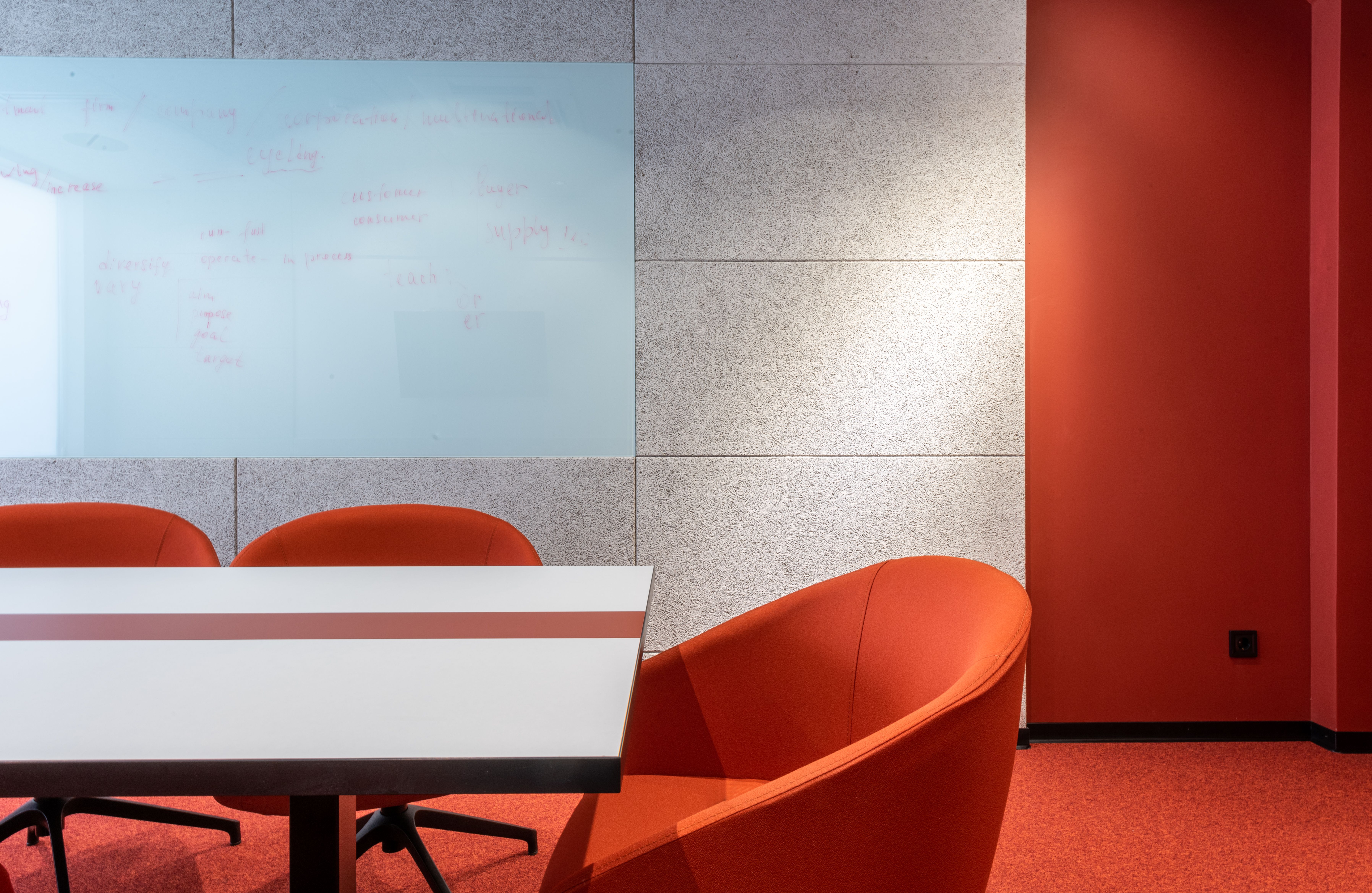 comfortable-orange-chairs-placed-on-rug-at-white-table-near-wall-with-projection - max-vakhtbovych (pexels)