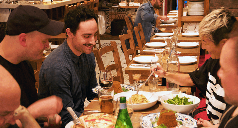 A photo showing people chatting at a restaurant table.
