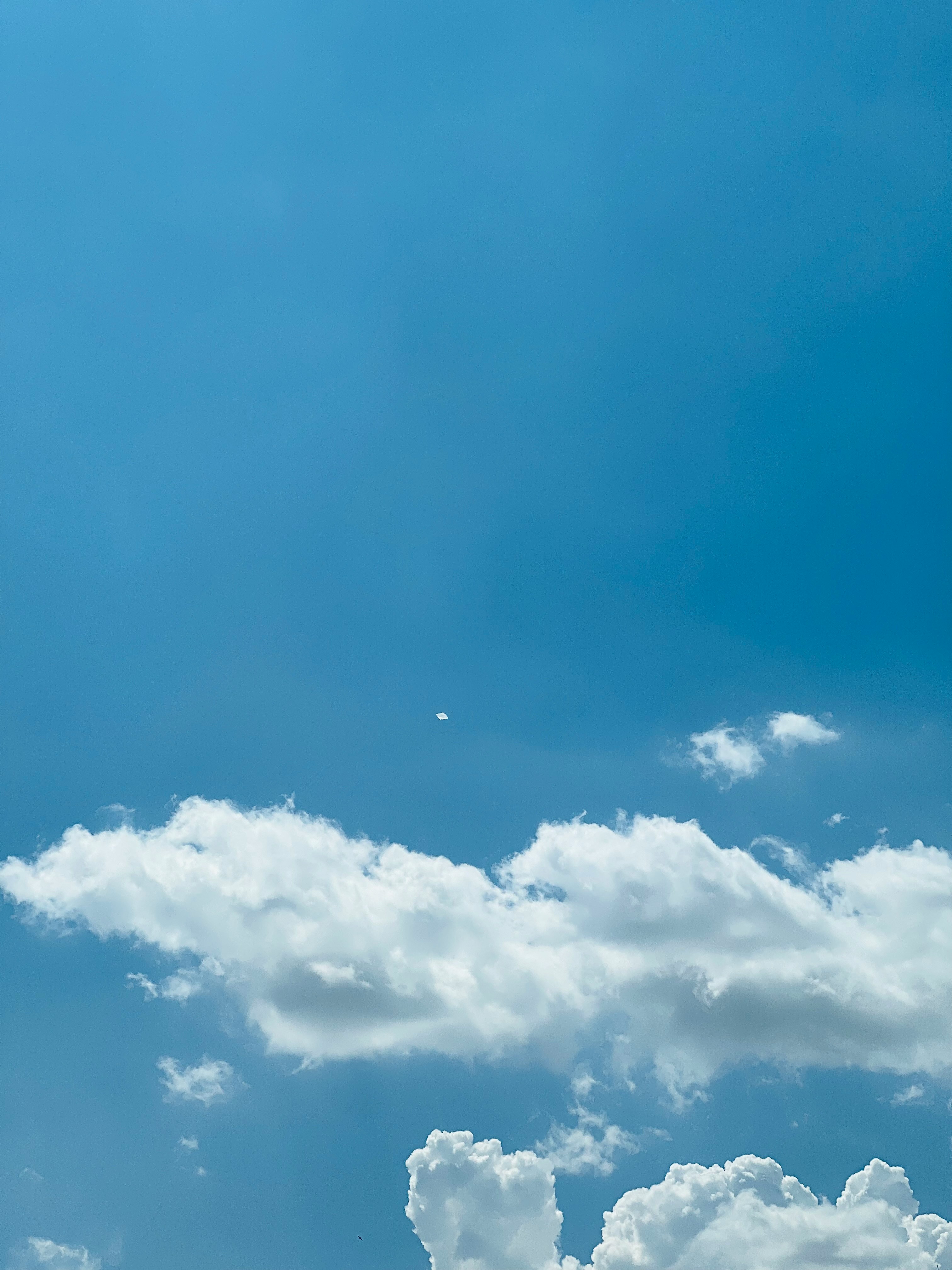 a plane flying high in the sky with clouds