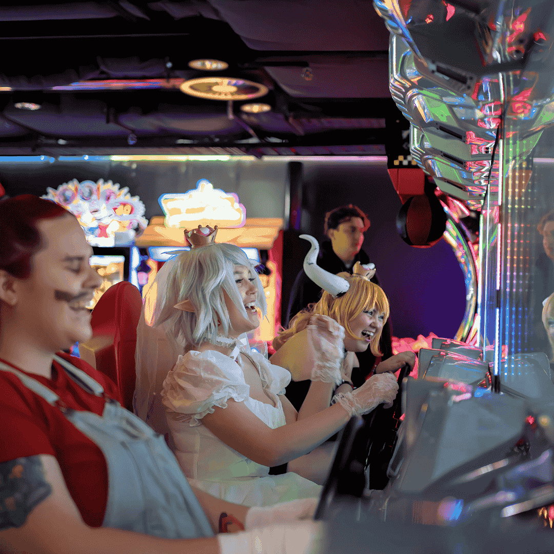 group of people playing arcade machines dressed as mario bros characters