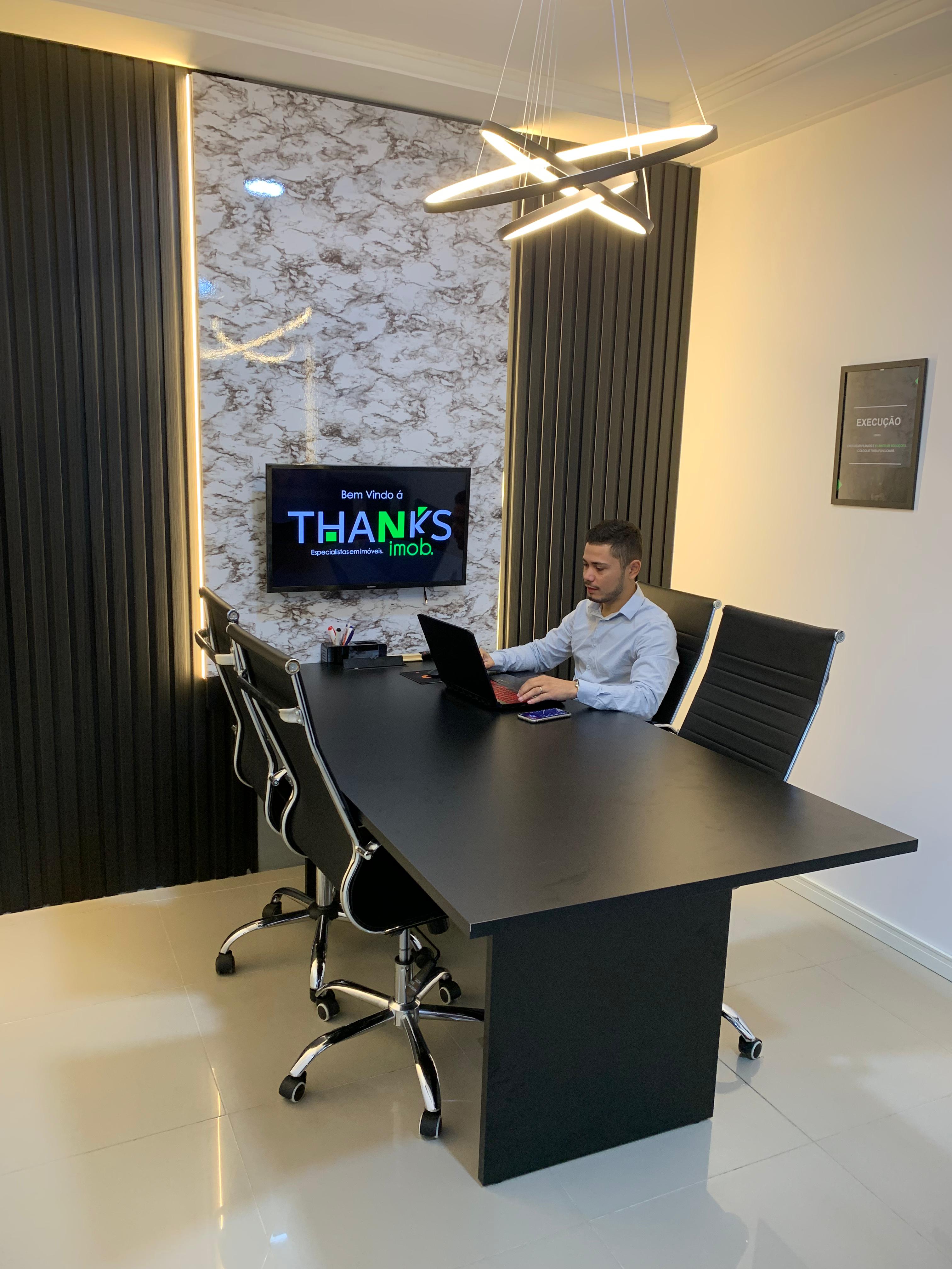 A white building with a balcony and windows, representing an apartment complex, set against a serene blue sky.
