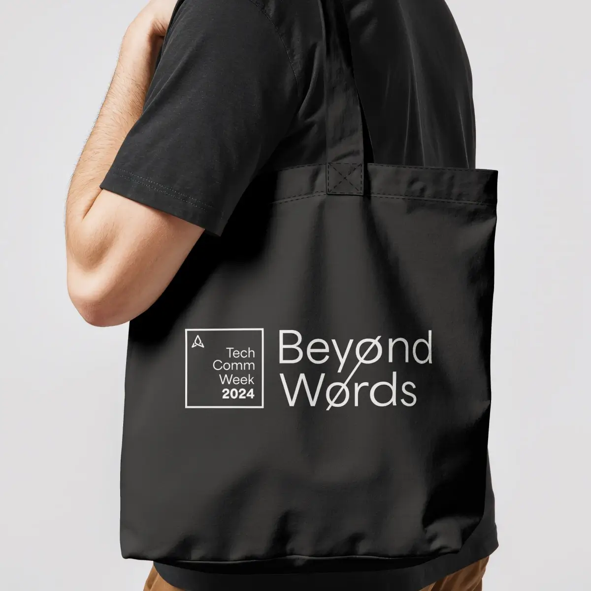 A person carries a black tote bag with white text reading "Tech Comm Week 2024" and "Beyond Words." The style is modern and tech-focused.