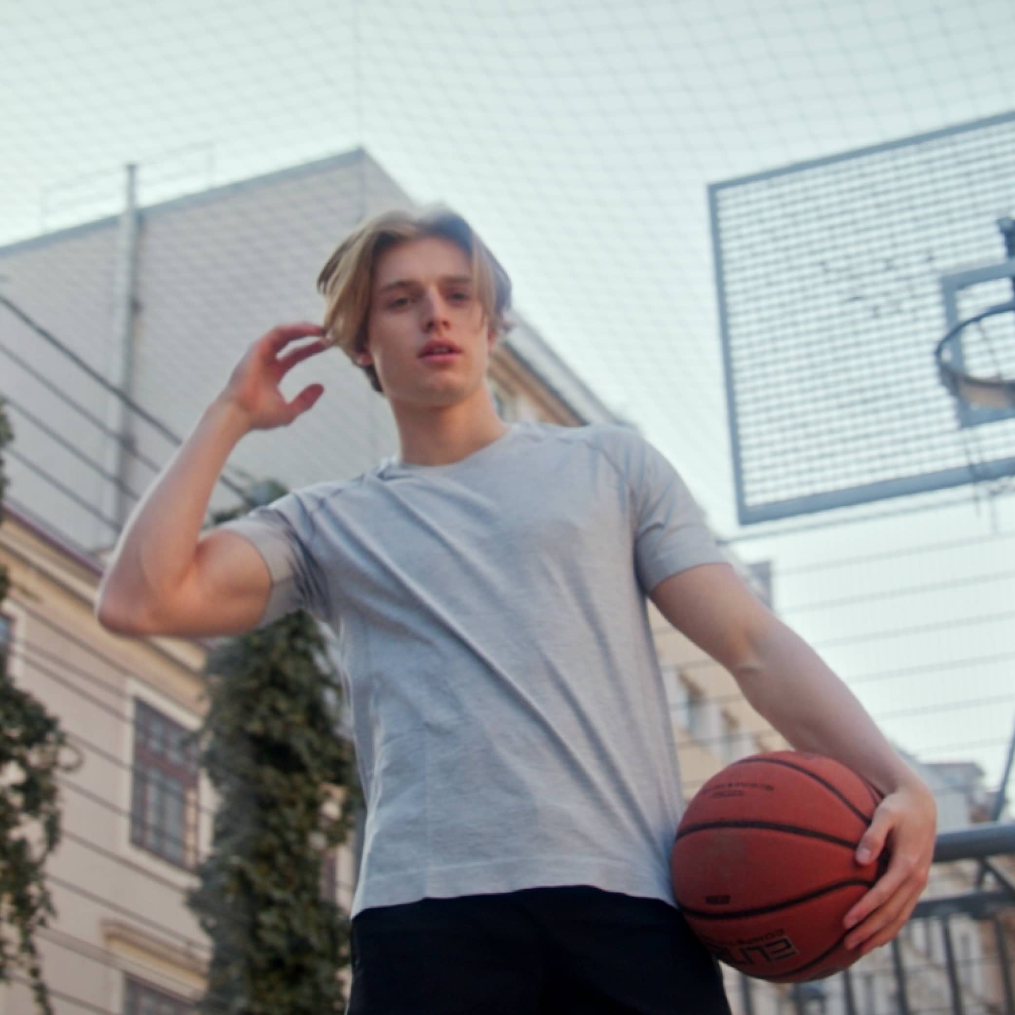 Mann auf einem Basketballplatz, der in die Kamera schaut