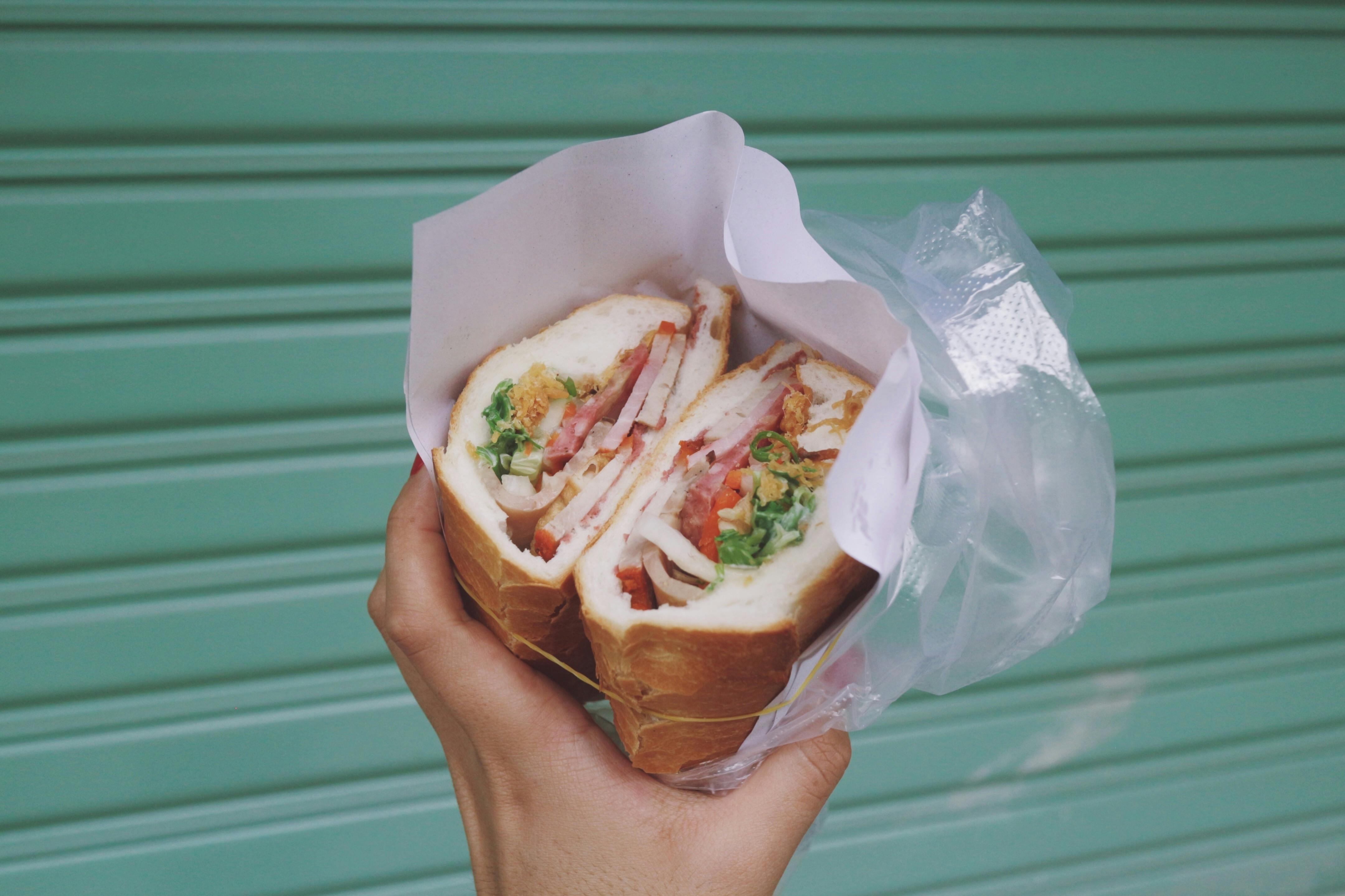 a man holding a Bahn Mi sandwich