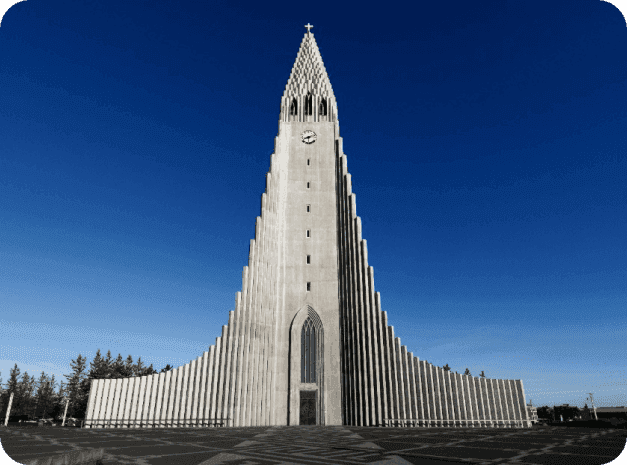 Front view of Hallgrímskirkja’s towering concrete façade beneath a deep blue sky.