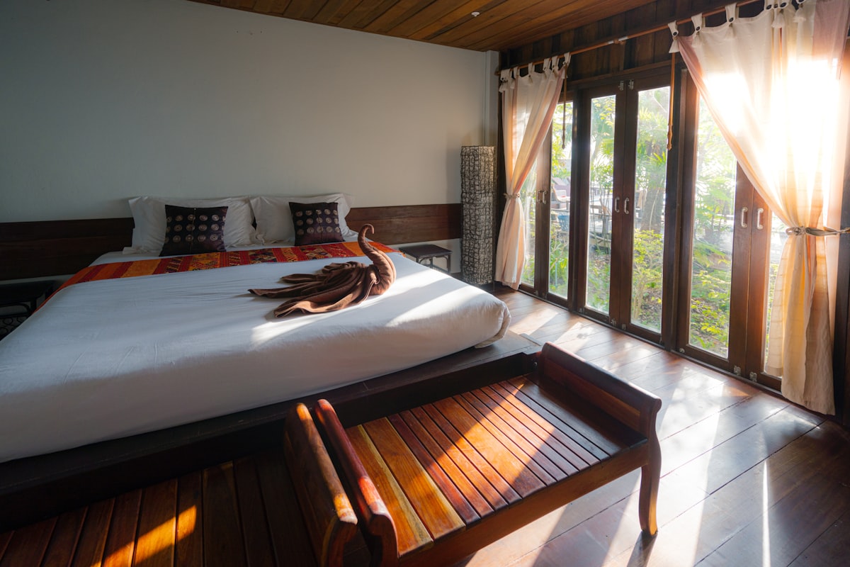 Vacation rental bedroom with a large bed and sunlit glass doors, suggesting revenue in each reservation