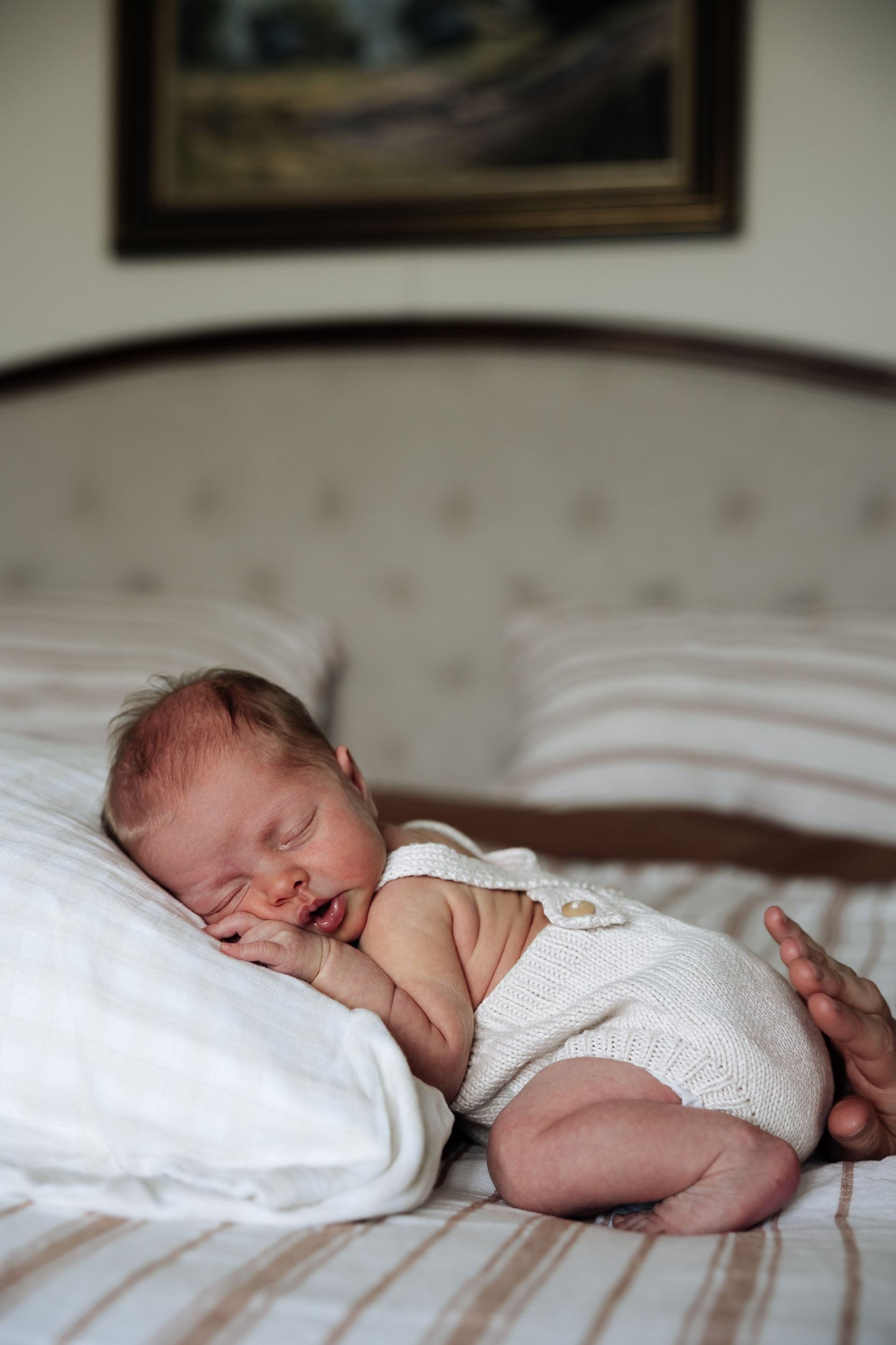 Newborn baby laying on pillow in soft light