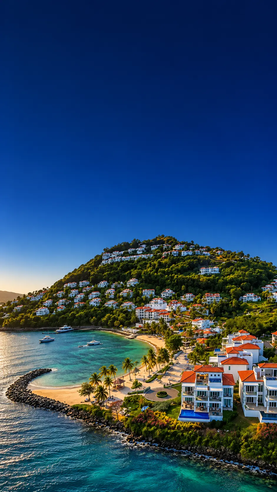 Aerial view of a hillside resort in Saint Lucia with red-roofed villas above a curved beach and turquoise bay at golden hour