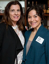 A photo of two women standing in a room.