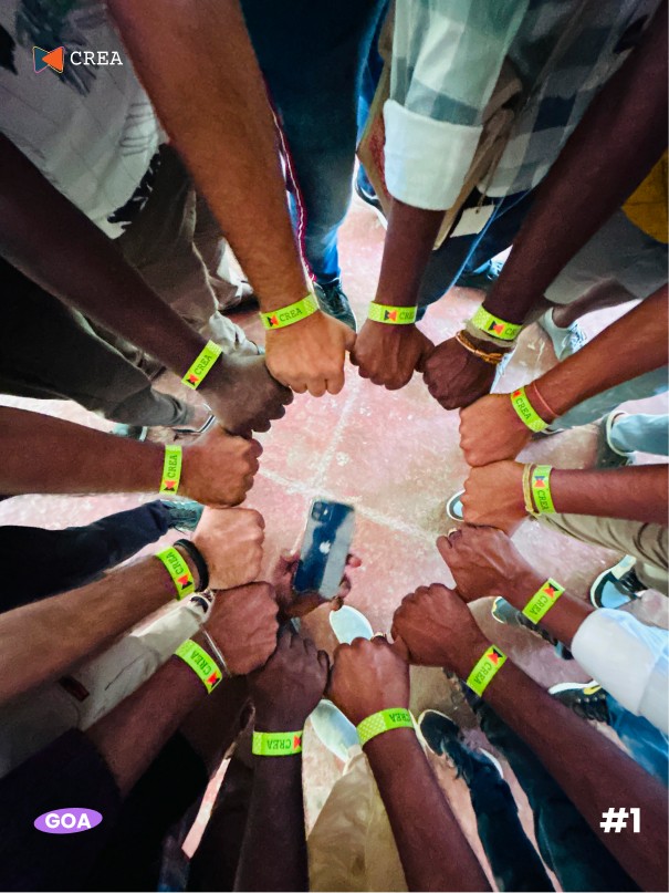 A winding road cuts through rocky terrain, surrounded by patches of green grass and illuminated by sunlight.