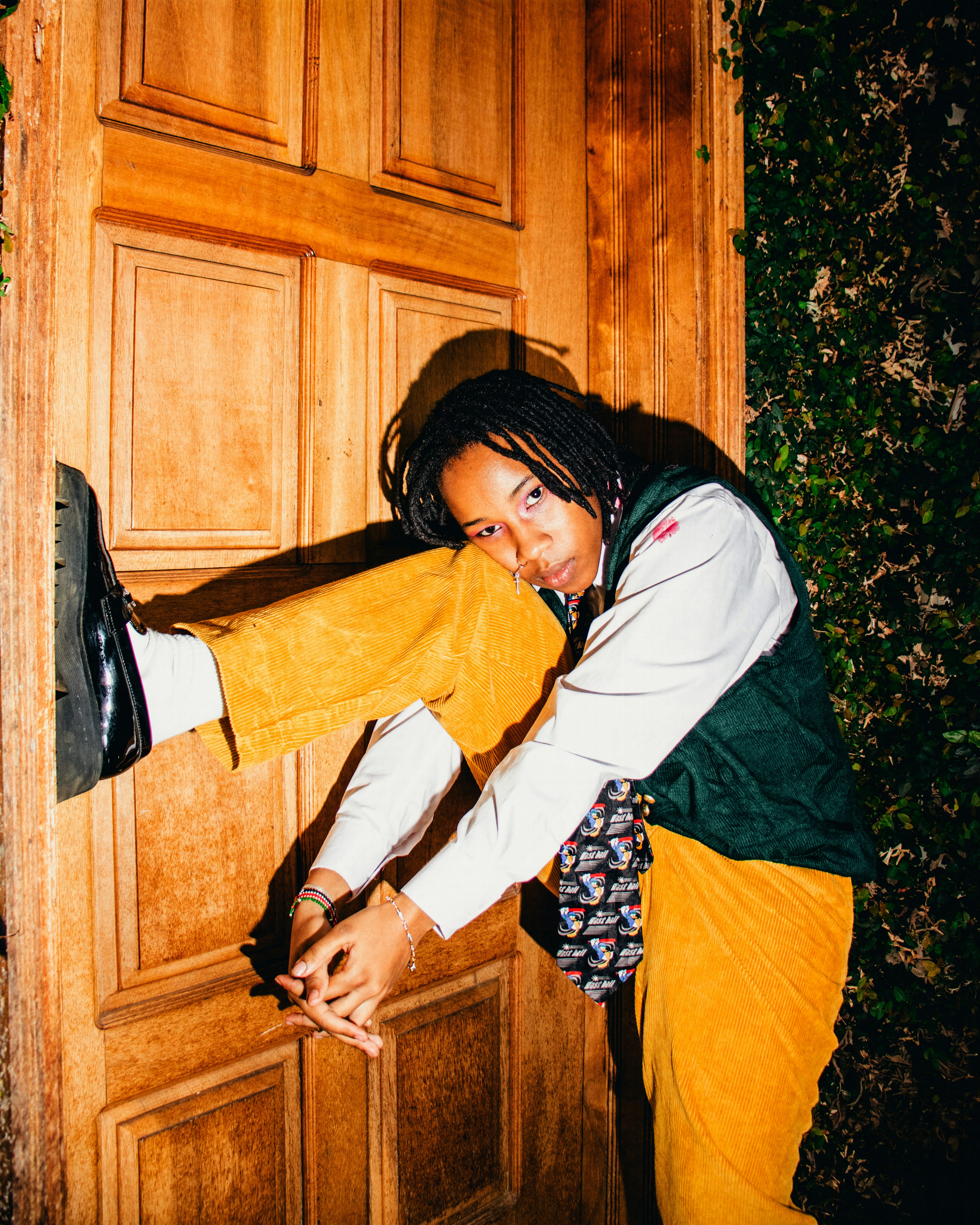 A woman is opening a wooden door with her hand