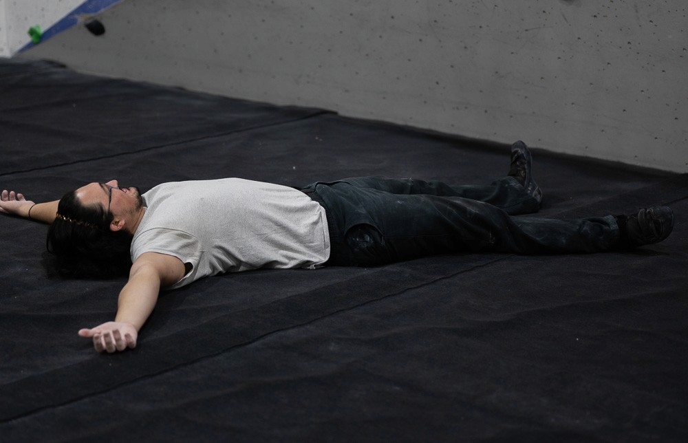 man lying down in climbing gym