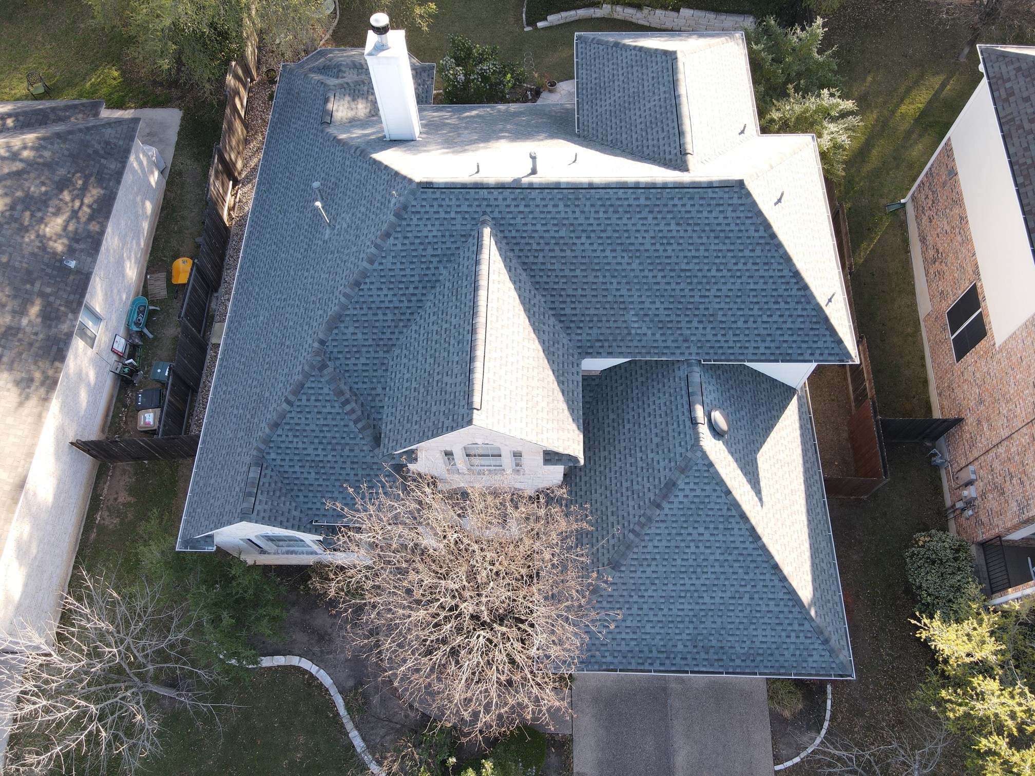 Large GAF HDZ architectural shingle roof with a chimney and dormers, combining durability and visual appeal in a classic design.