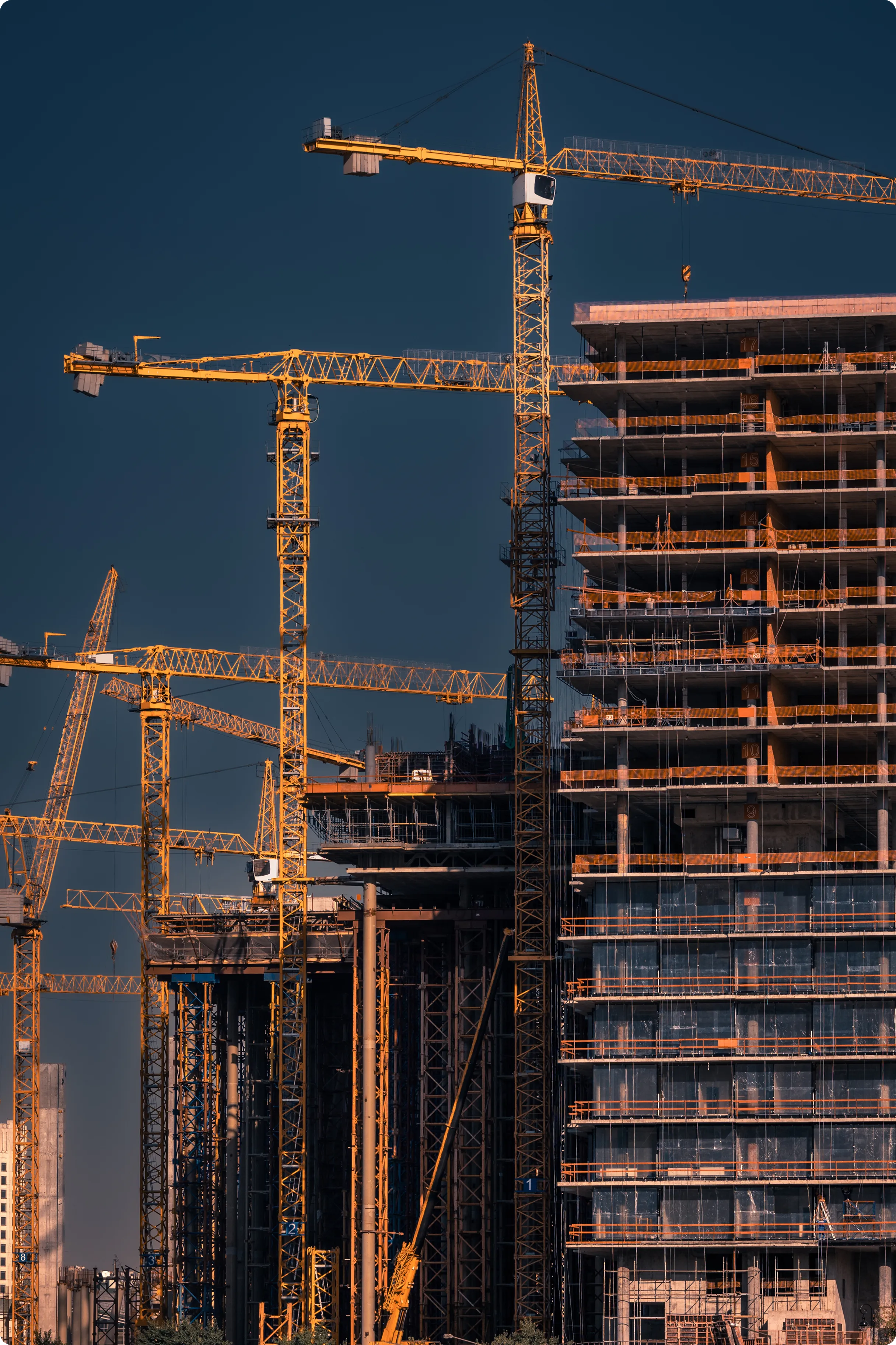 Multiple concrete high-rise buildings undergoing active construction with cranes.