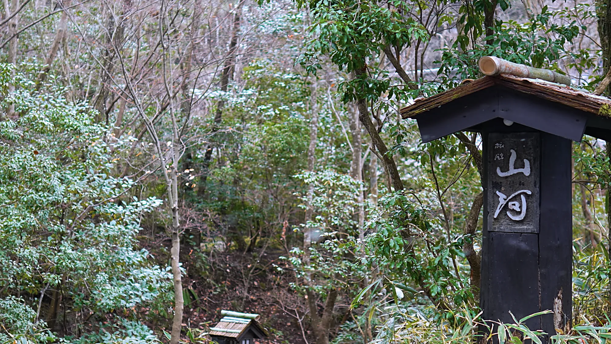 The timber pillar sign for Sanga at Kurokawa Onsen, under a small roof