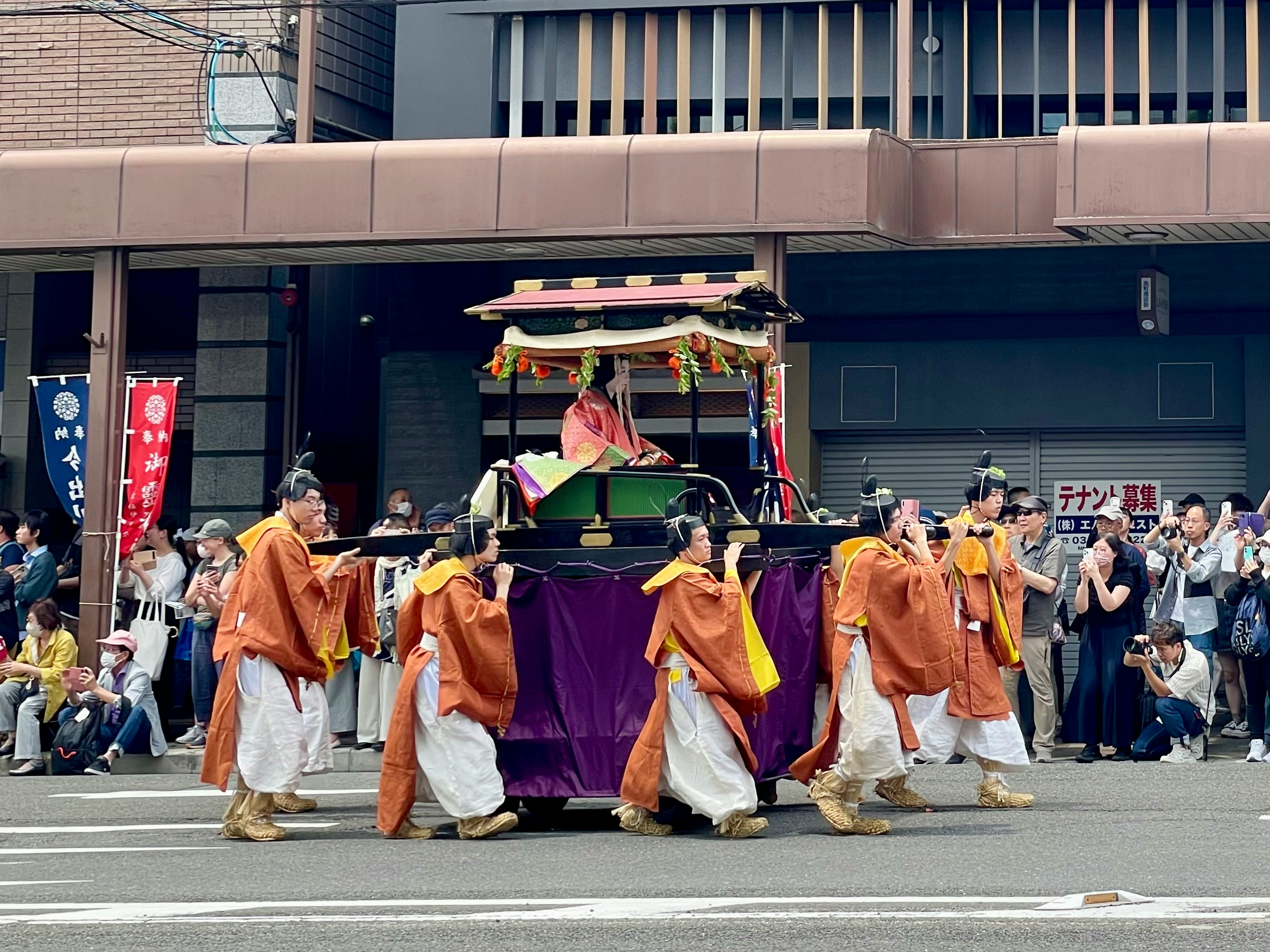 People carry a traditional japanese float in a parade.