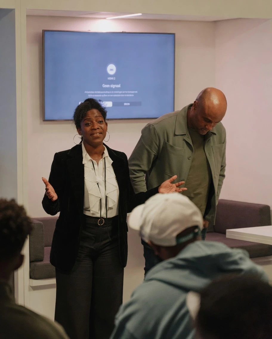 Two professionals discussing a presentation in a workshop setting
