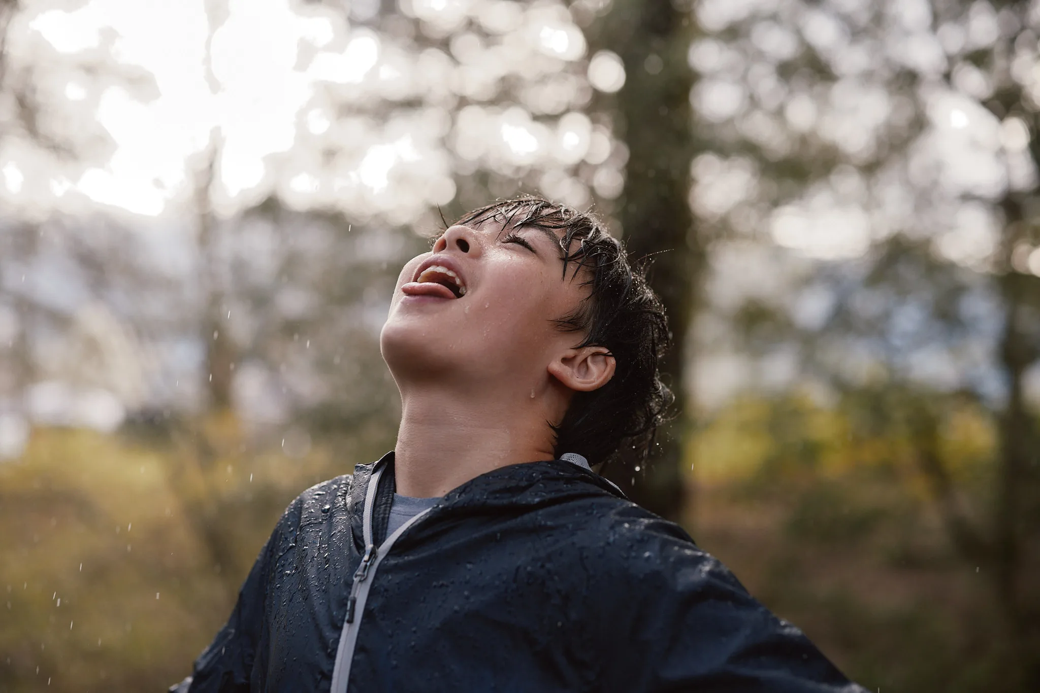 boy catching rain on tongue — lifestyle photography by Tom Kubik