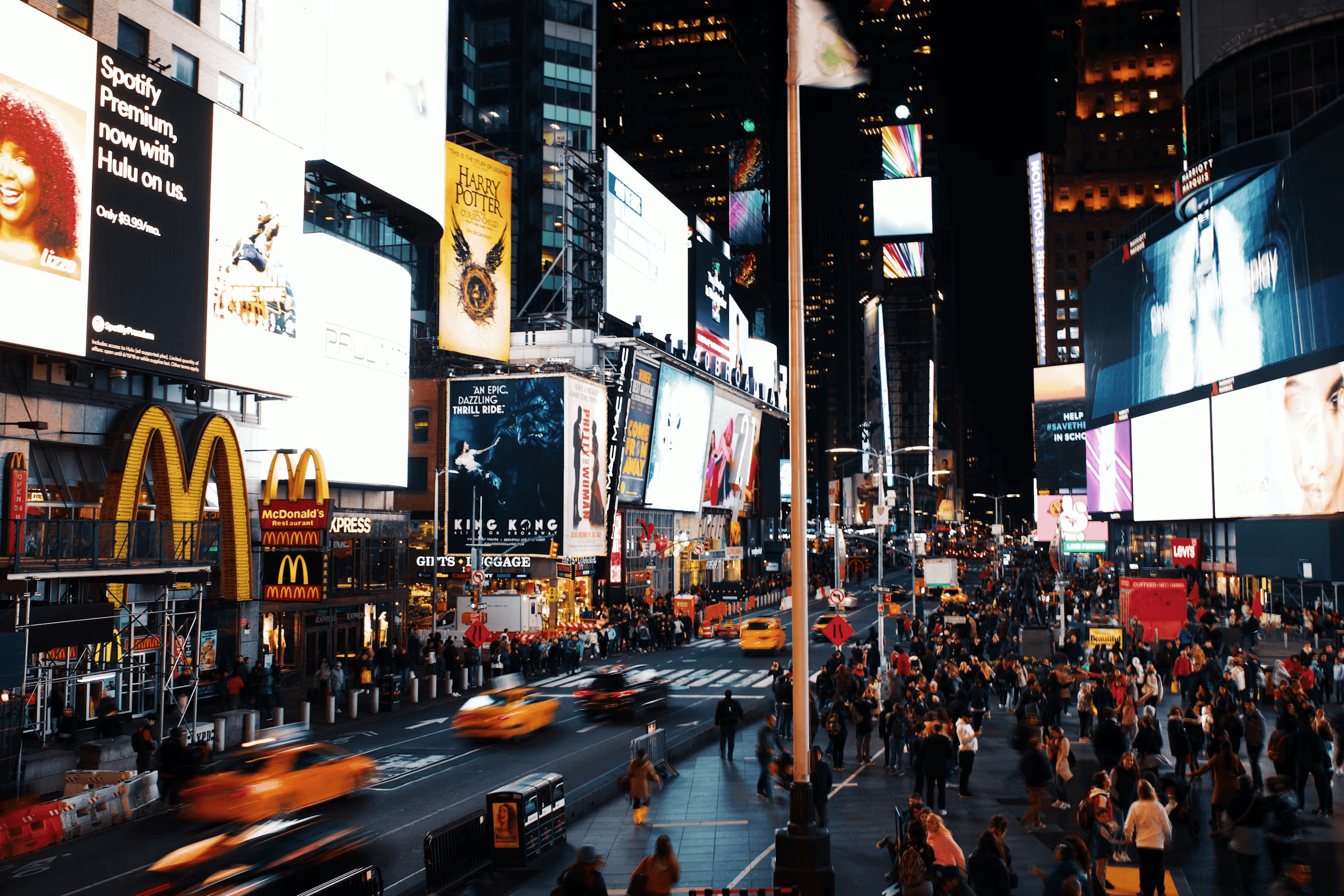 Times Square at night with billboards and crowds
