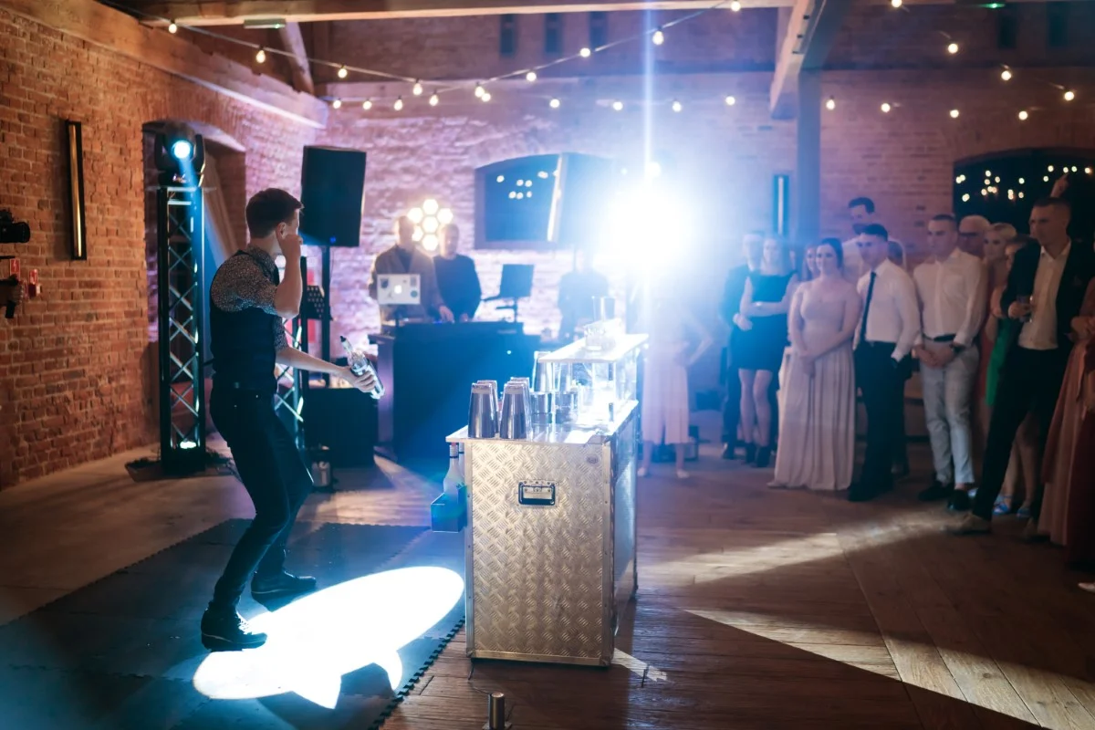 Atrakcje weselne – barman wykonuje pokaz barmański na mobilnym barze.