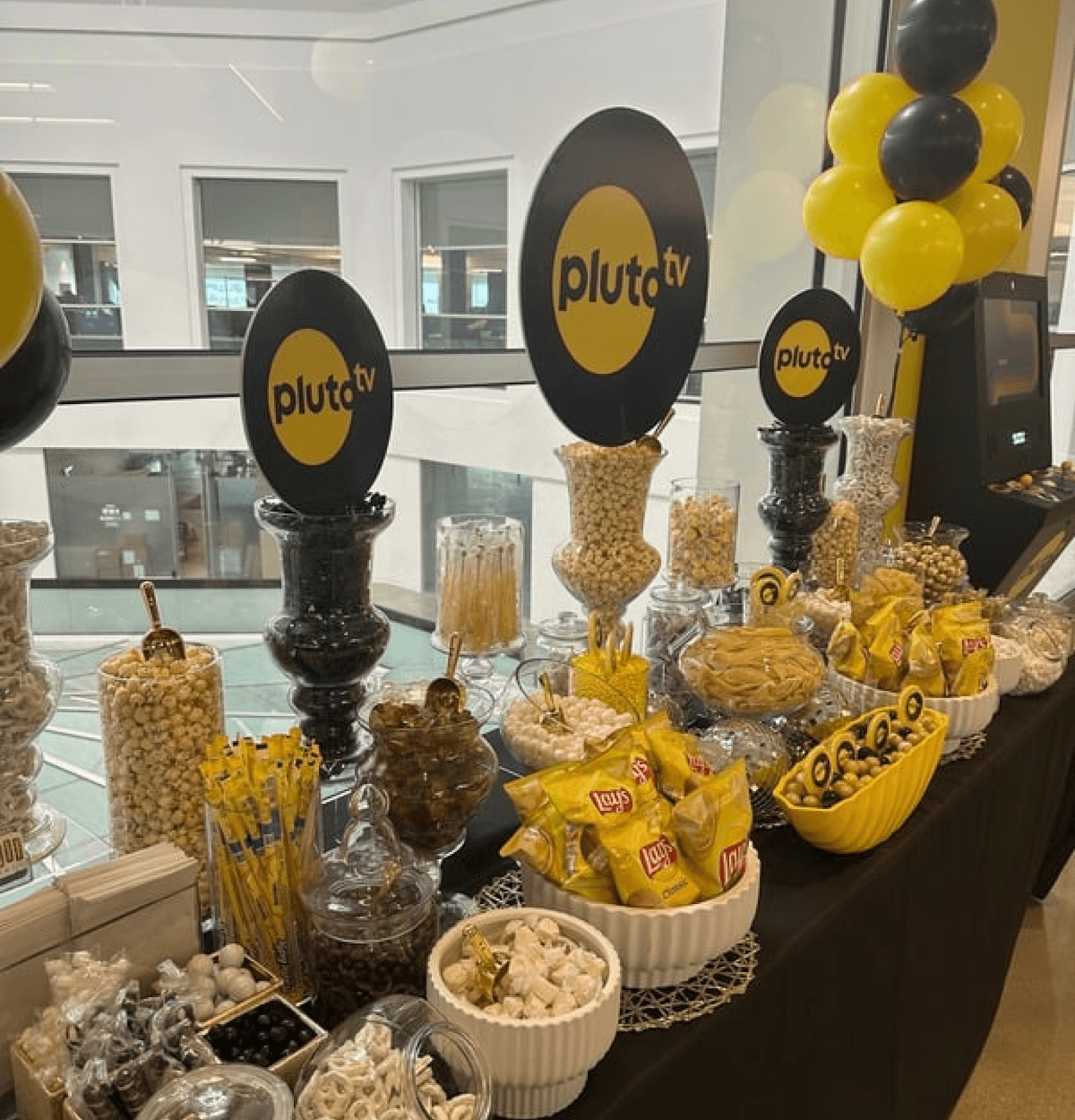 Elegant table setting with gold glassware and custom branded balloons for a corporate event.