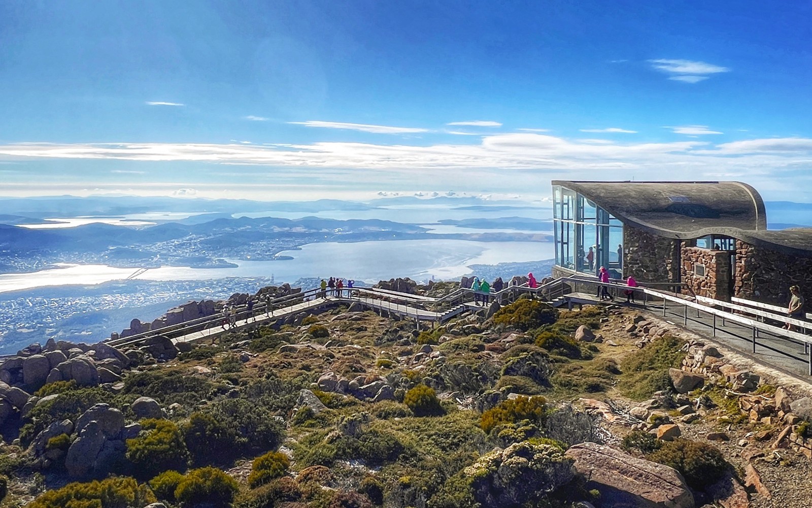 Visitors walking on the boardwalk at Mt Wellington summit, overlooking Hobart, Tasmania.