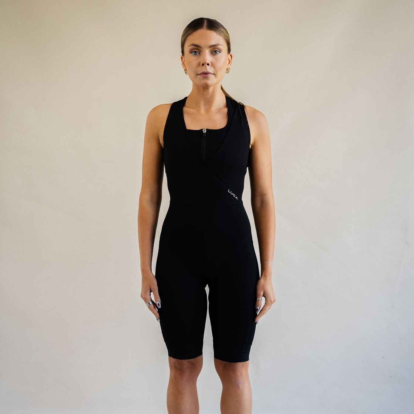 Cyclist wearing LUCA Road All-In-One Cargo bib shorts in black, front view