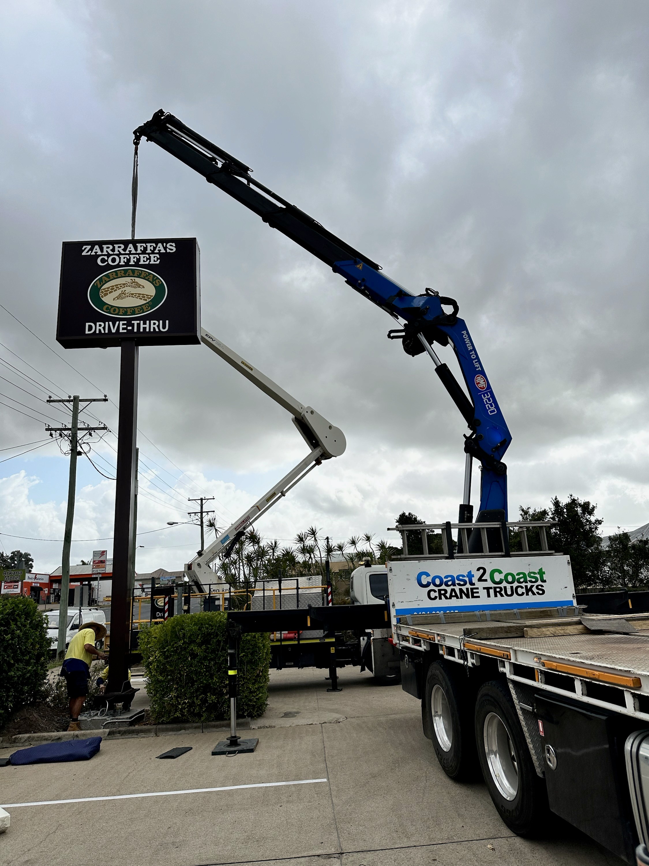 Crane truck lifting a sign