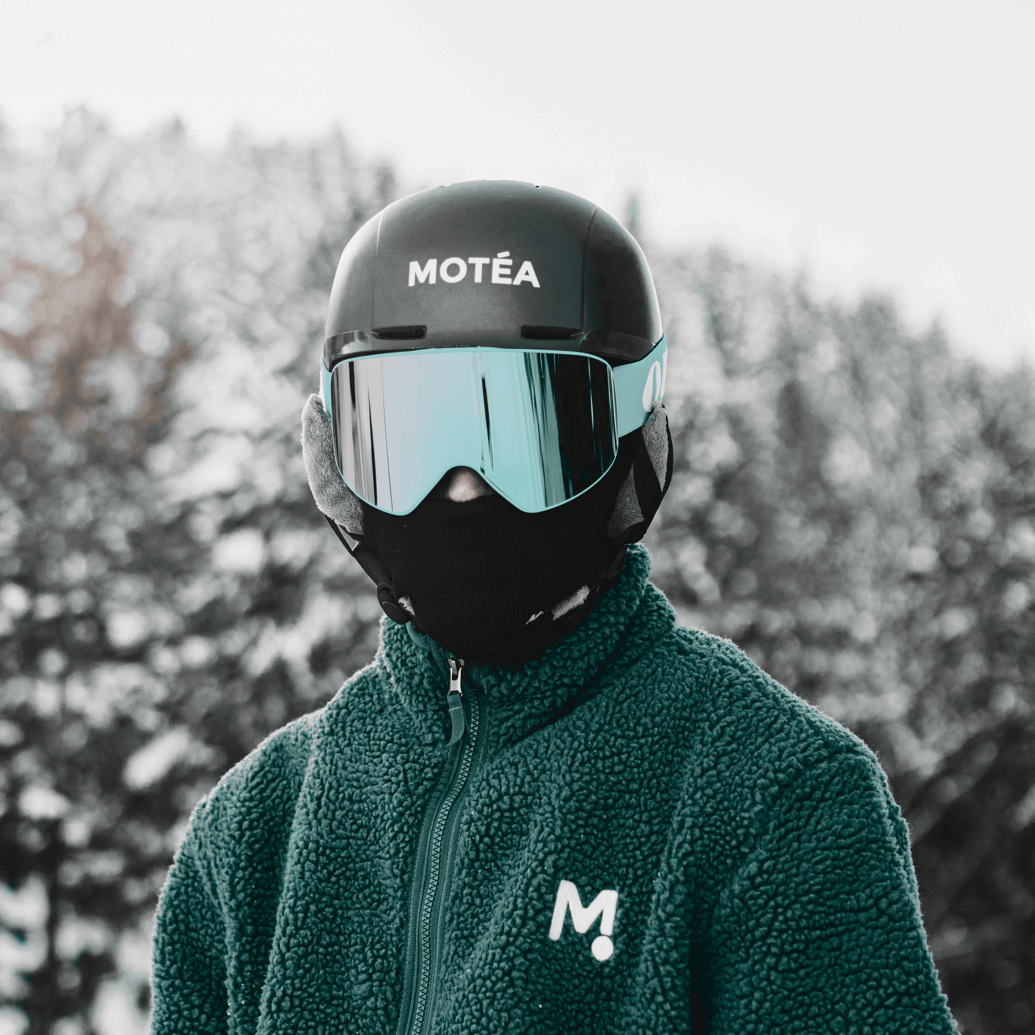 a person wearing a green jacket and a black helmet