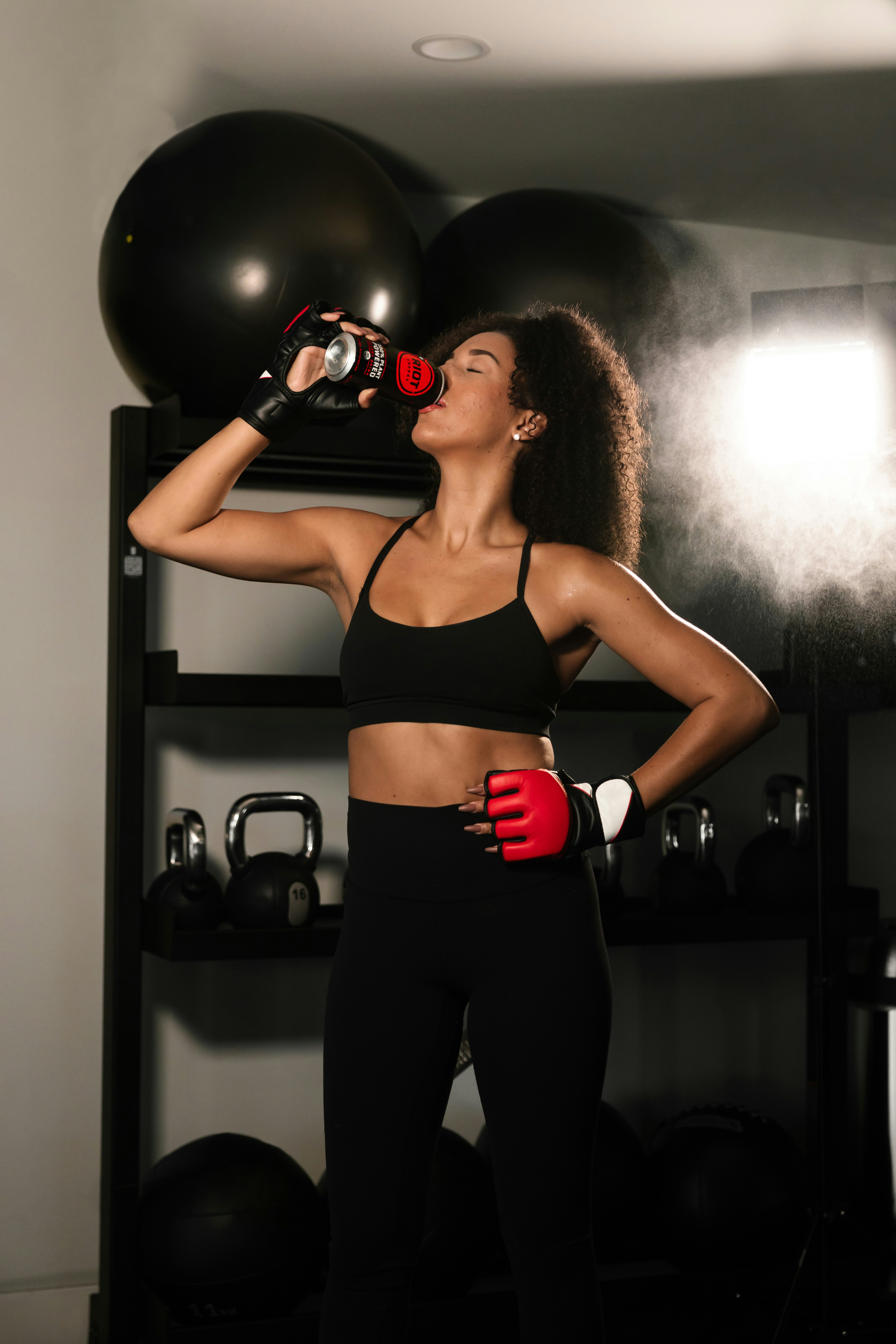 Woman having a pre-workout drink in the gym.