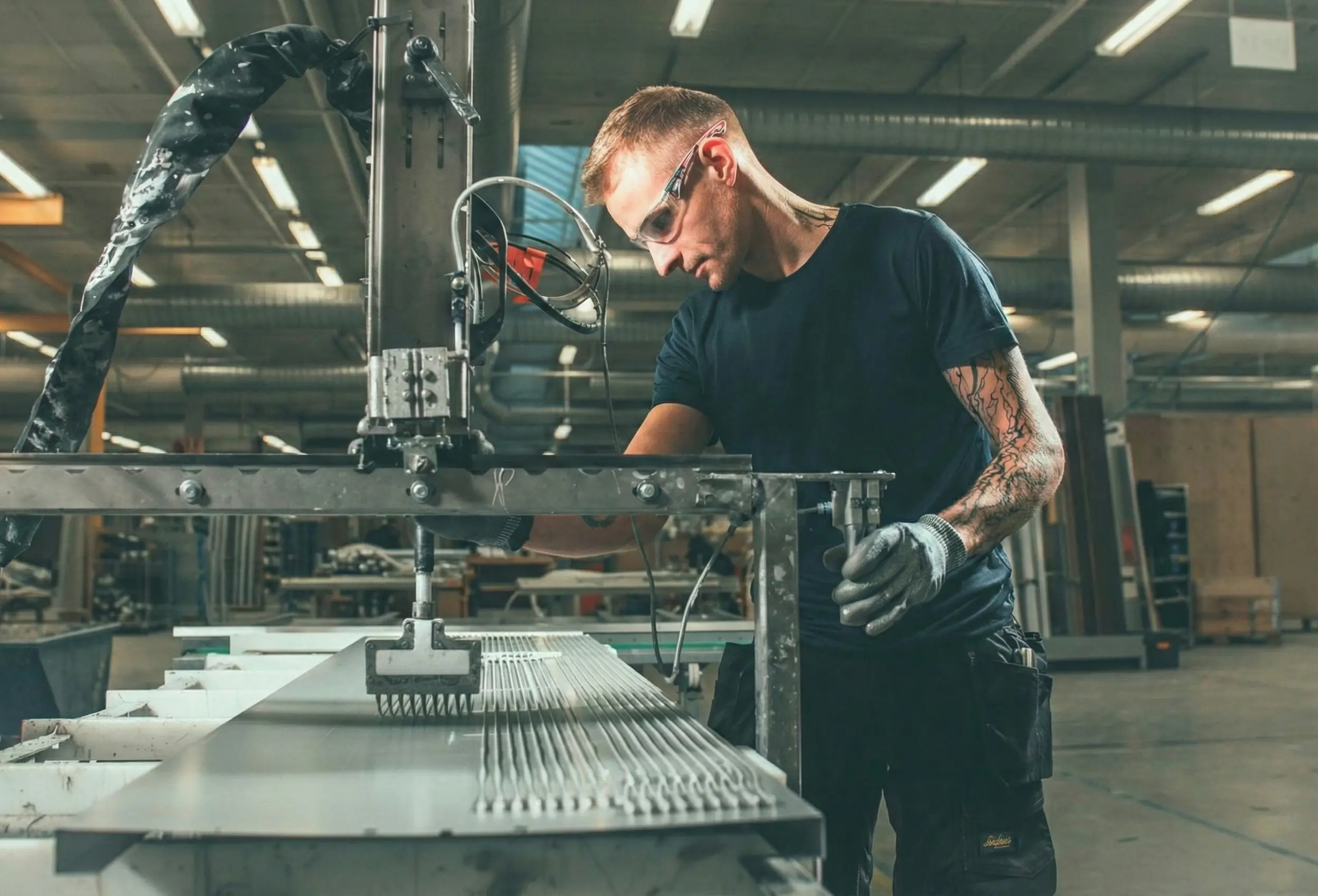 A factory worker operating the gluing station in a Finnish bathroom pod factory