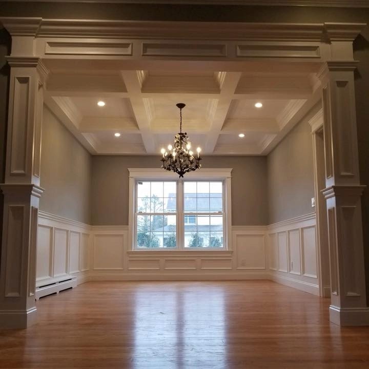 Dining room renovation with coffered ceiling, chandelier, and custom wall paneling