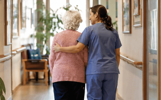 Una cuidadora abraza a una residente anciana en Gijon