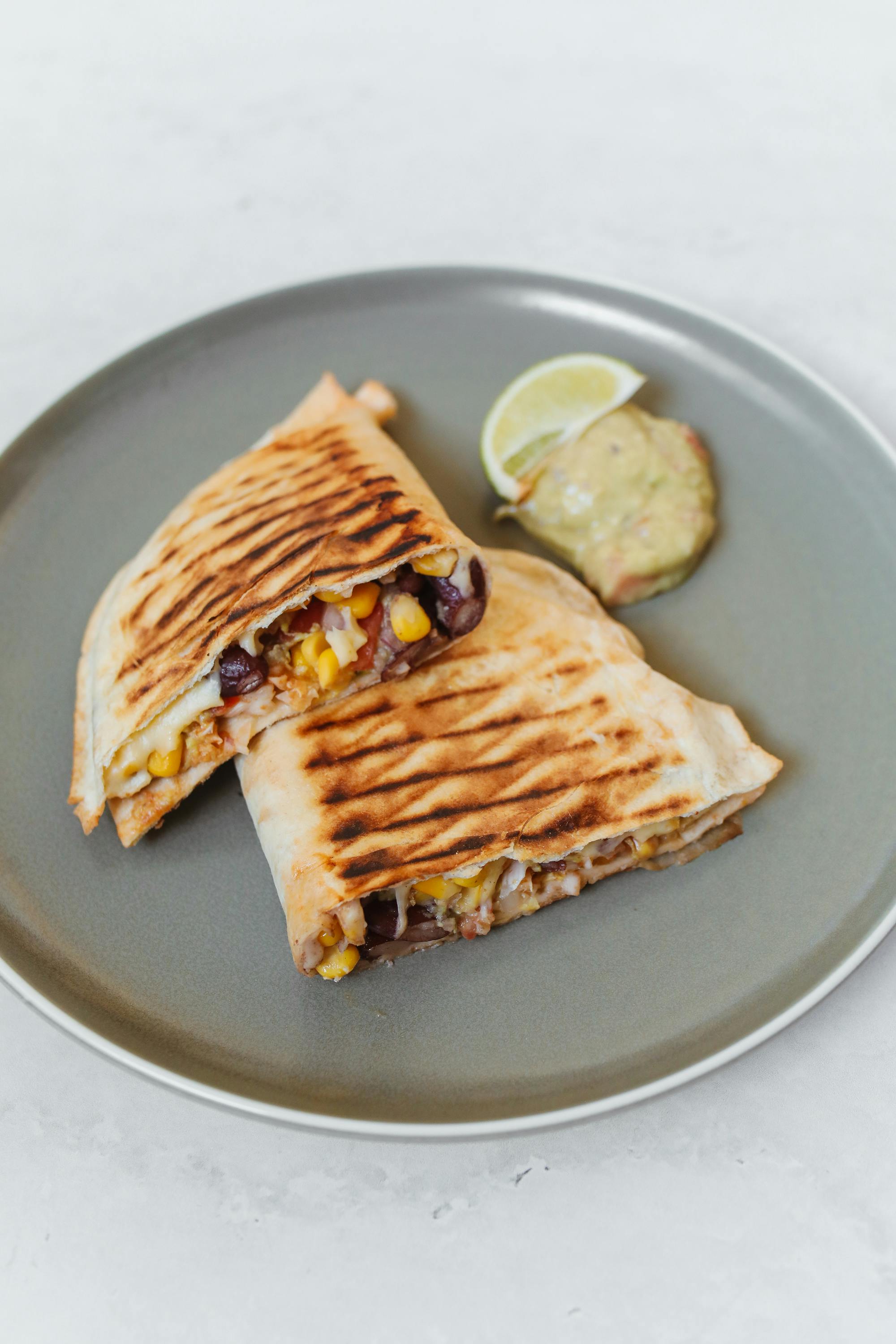 Vegetarian Quesadilla Grilled flour tortilla filled with cheese, bell peppers, onions, mushrooms, and tomatoes. Garnished with guacamole, sour cream, and lettuce.