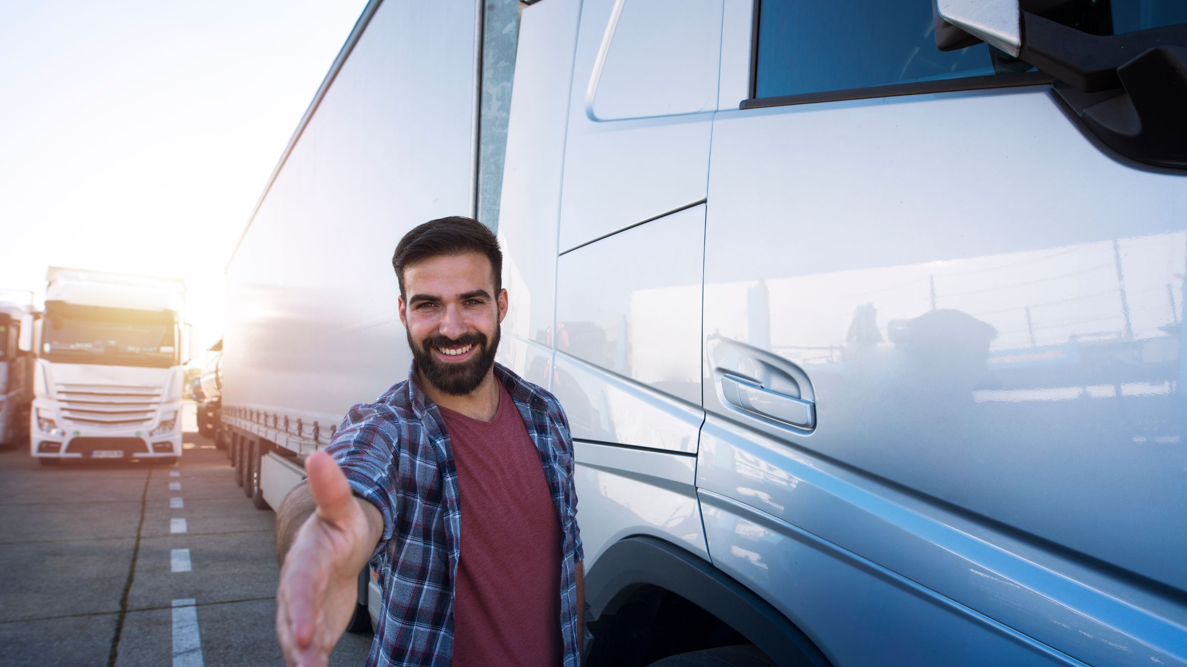 Truck driver shaking hand, representing hiring drivers for more trucking jobs 