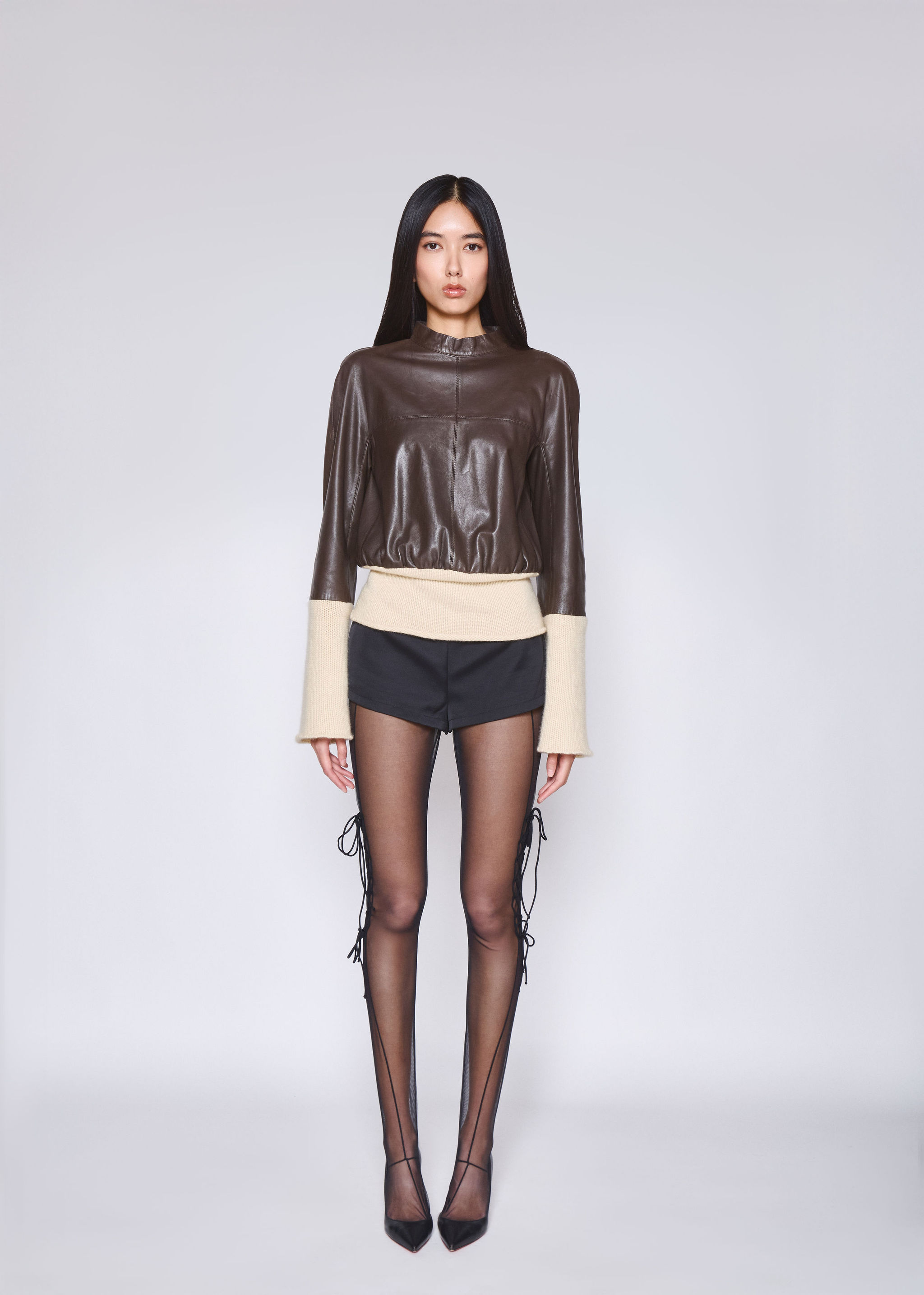 Young woman with dark hair and bangs, wearing red.