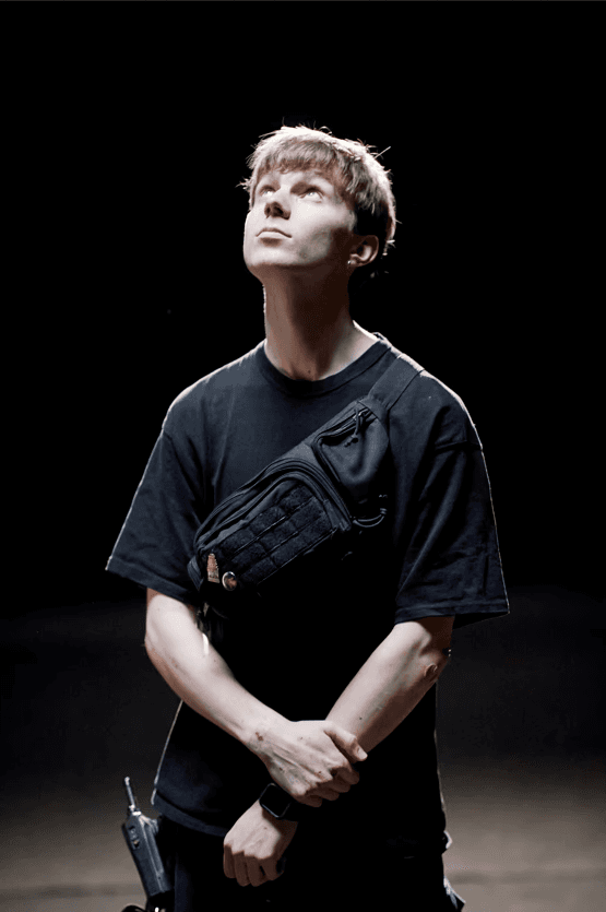 Person, holding a white rose behind his back with one arm on a light blue background