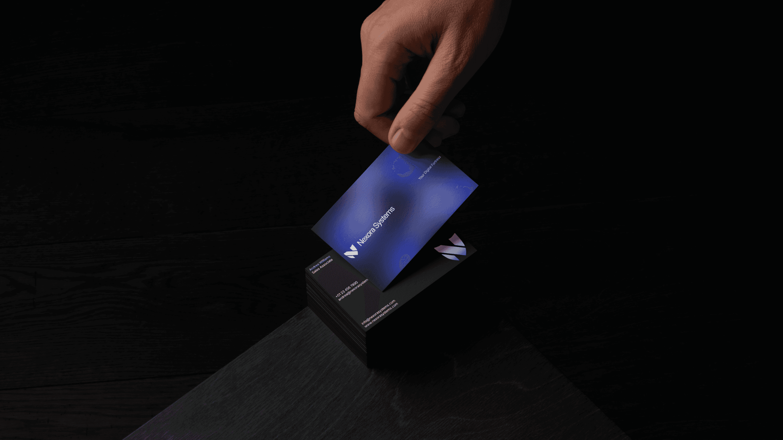 A stack of business cards on a table. The business cards feature a simple, minimalist blue, black, and white design.