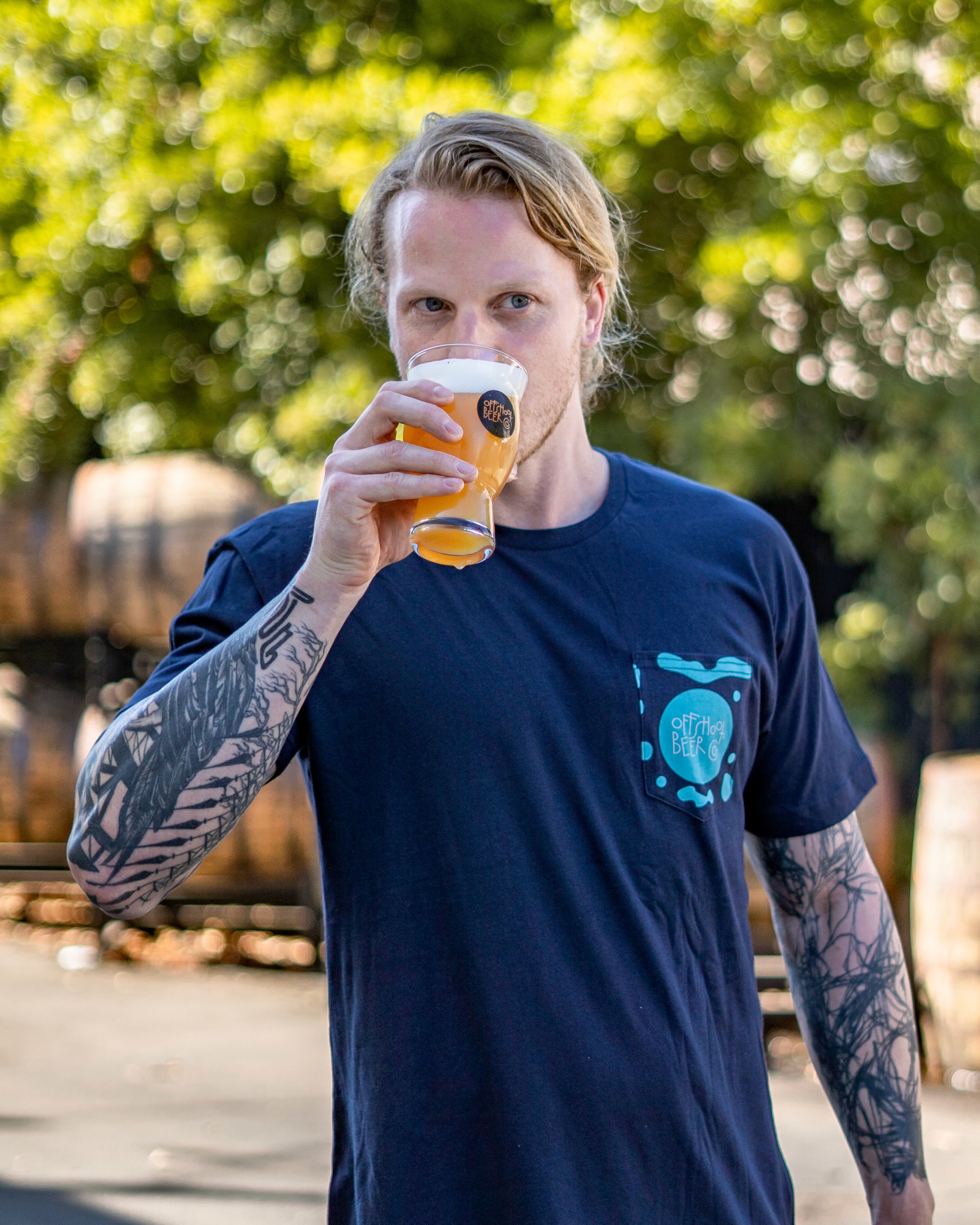 Person drinking beer wearing Offshoot Beer Co. t-shirt