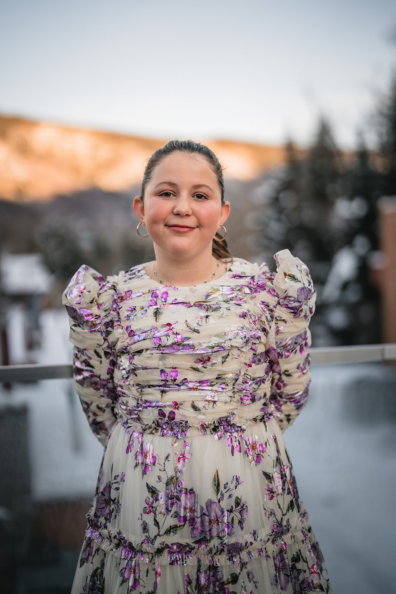 Bat mitzvah portrait outdoors with snowy Aspen mountains behind her