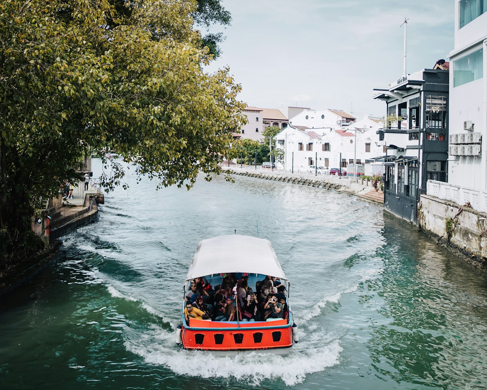 A river cruise boat winding through the heart of Melaka