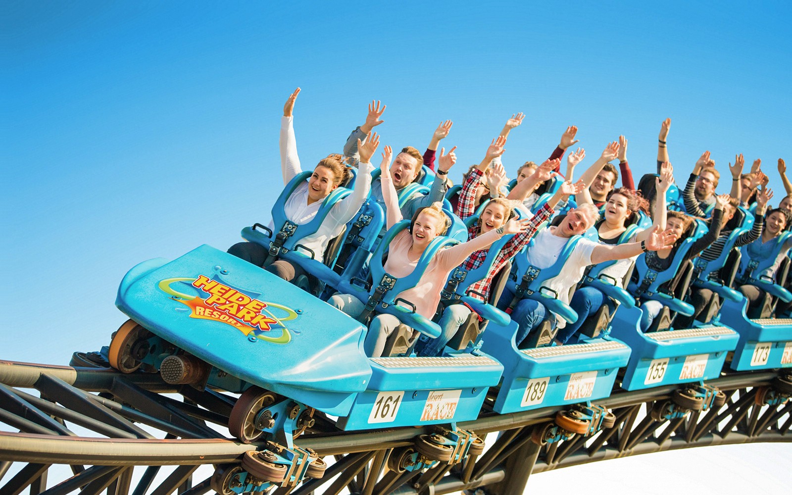 Roller coaster riders with raised hands at Heide Park.